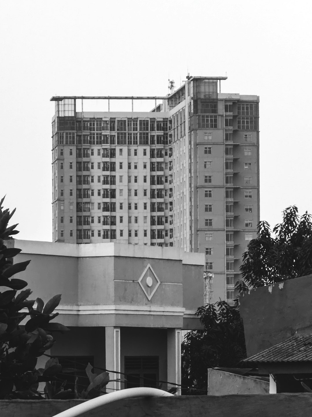 Modern high-rise apartment building behind an older brick structure.
